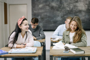Students in a classroom setting, focused and smiling while engaged in learning activities.